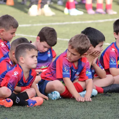 Jugadors petits asseguts a la gespa